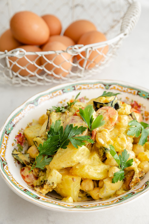 Sabich salad with eggplant, potatoes and boiled eggs in a decorative dish