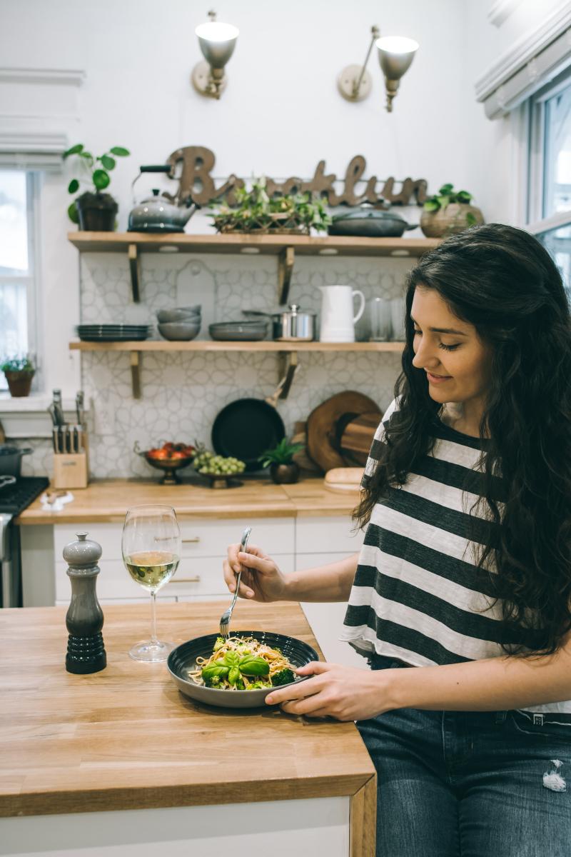 woman in kitchen with plate of food